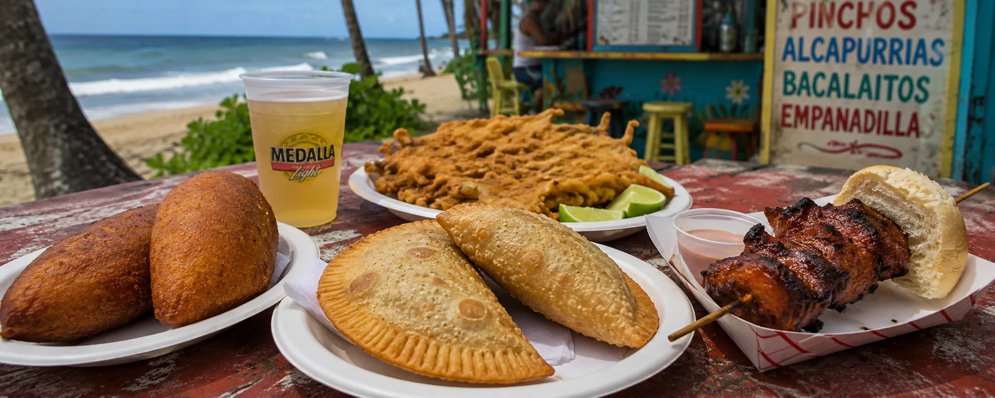 Puerto Rican street food including alcapurrias, empanadillas, bacalaítos and pinchos served at a beachside kiosk in Puerto Rico.