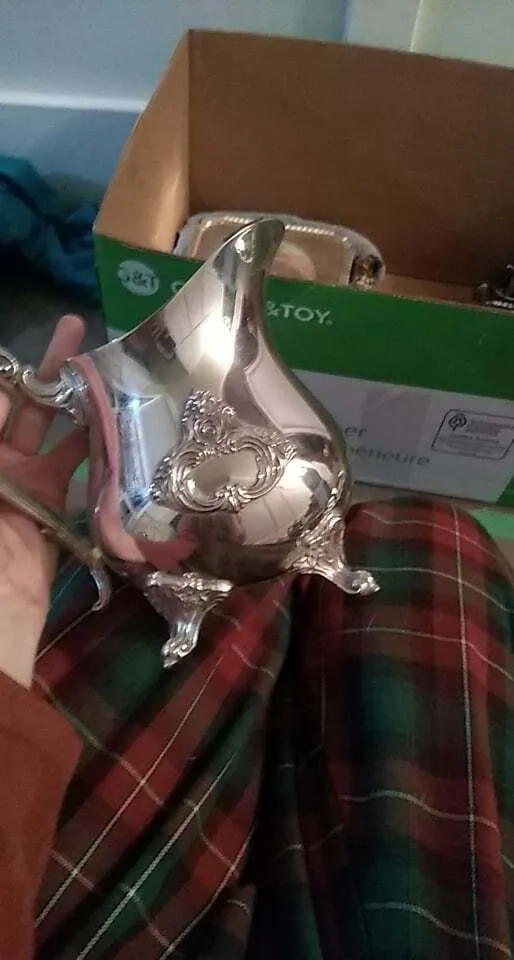 Small silver water pitcher with legs and raised emblem