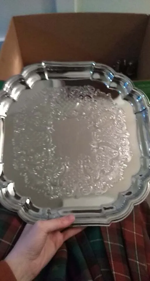 Polished silver square serving platter with scalloped rim and embossed bottom