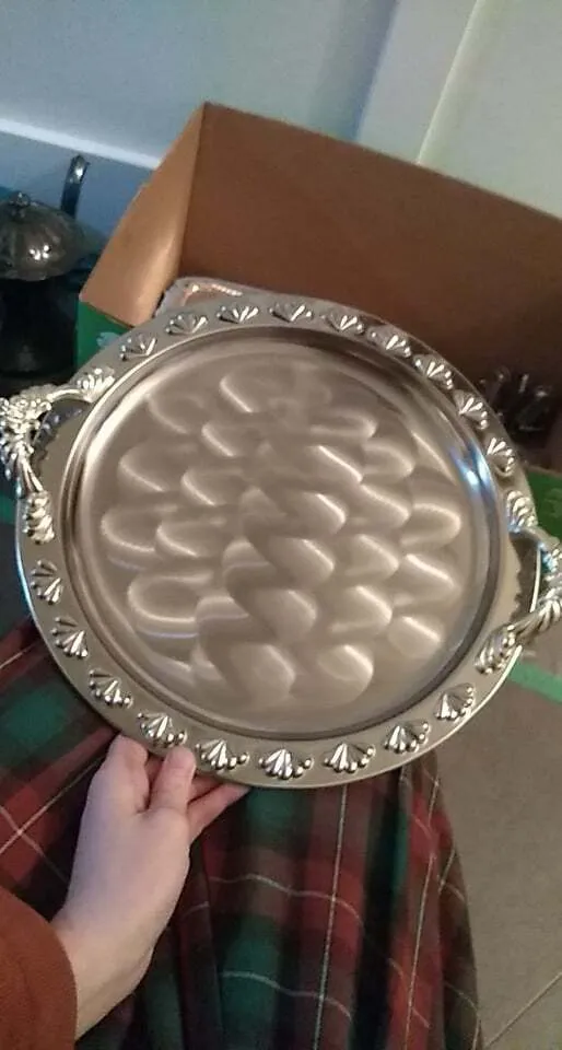 Polished silver round serving platter with handles and embossed edge