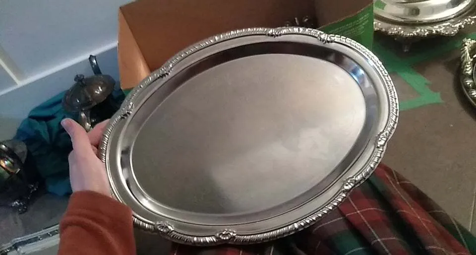 Polished silver oval serving platter with scalloped and raised edge