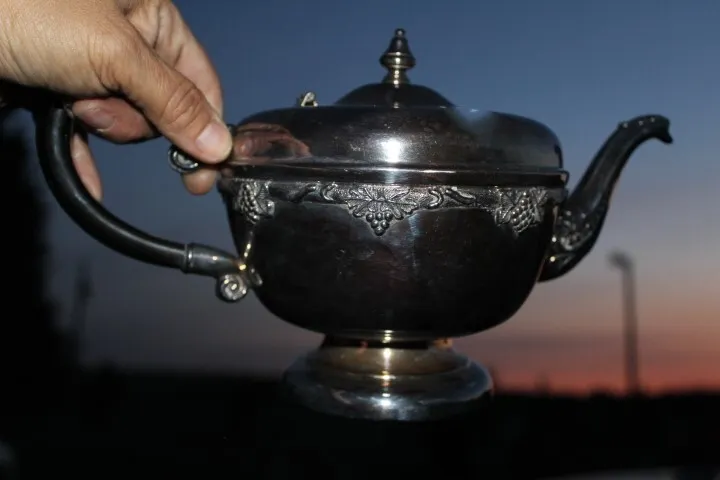 Silver teapot with black handle