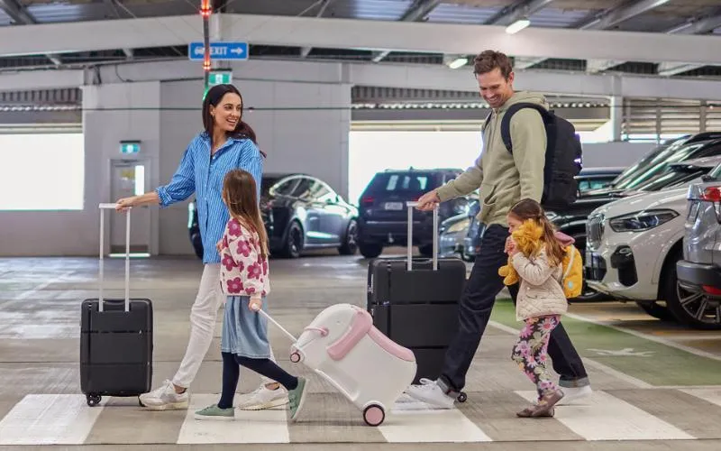 Family arriving into Auckland International Airport NZ with assistance using stroller