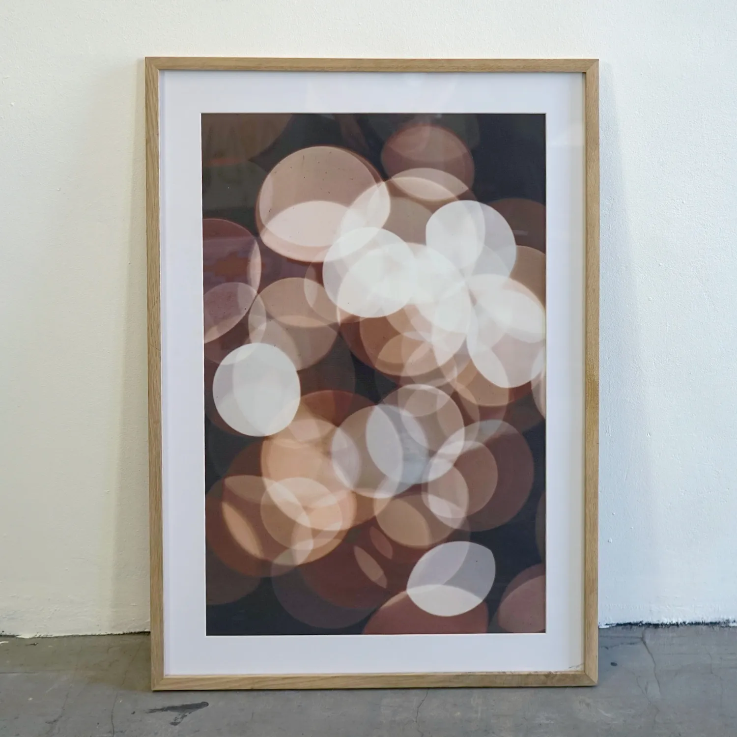 Mid tone wood frame with royalty free, brown abstract circle print, perspex cover