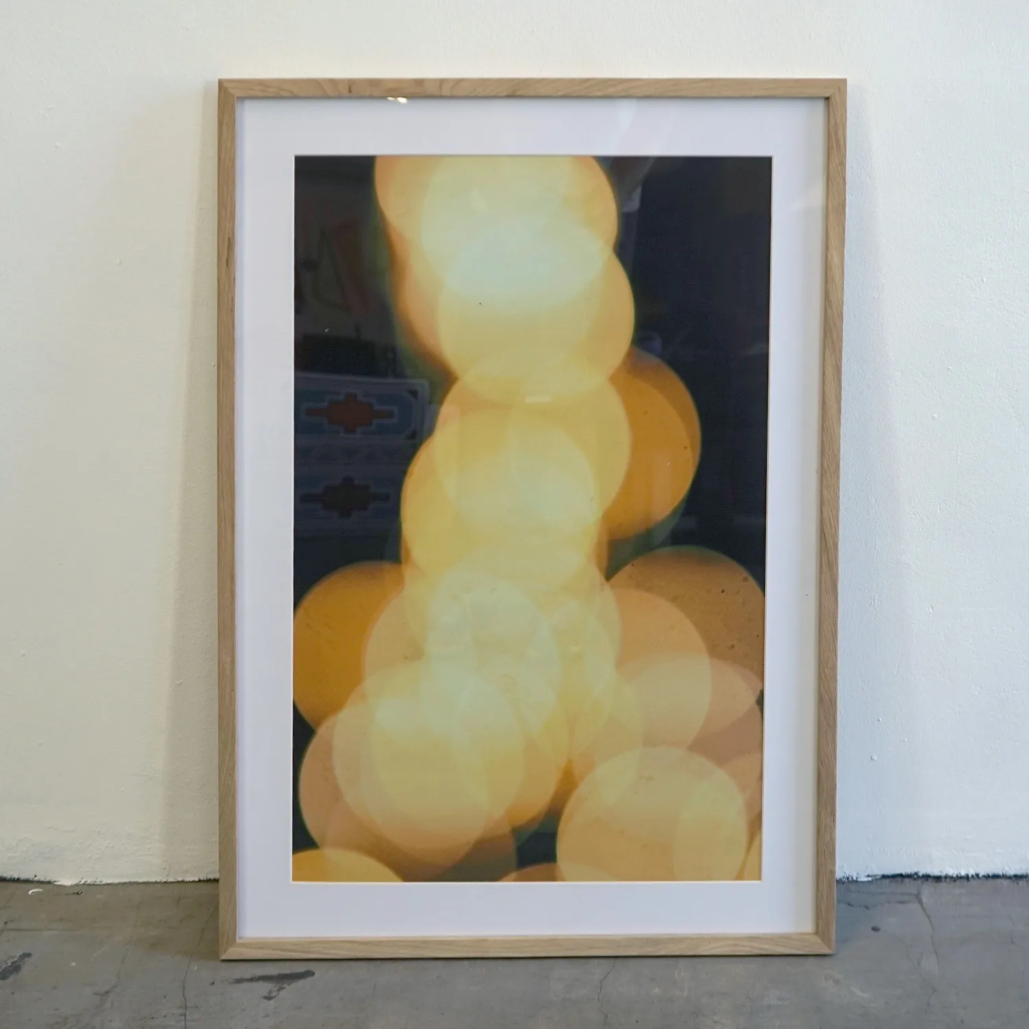 Mid tone wood frame with royalty free abstract print of out of focus yellow circles, perspex cover