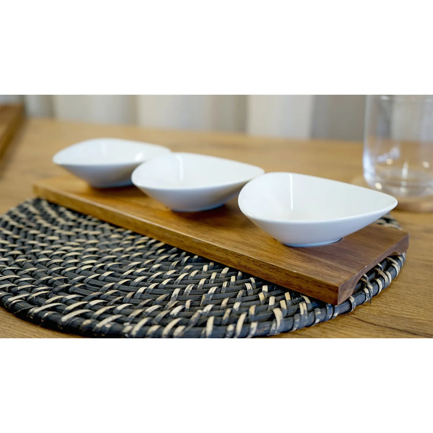 Three small white triangular bowls on wooden board