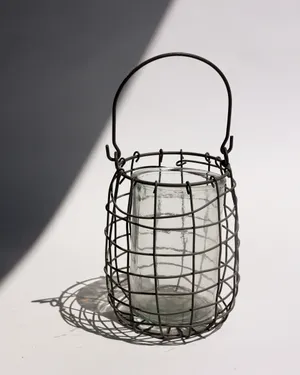 Atlantic glass lantern caged in rustic iron frame with handle