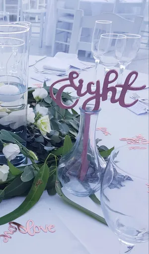 Cut out table number text in glass vase