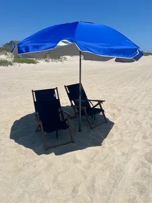 two chairs one umbrella