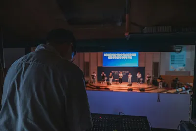 Sound technician checking an audio mixing console before a live event.