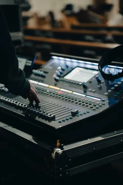 Sound engineer operates mixing desk in Adelaide.