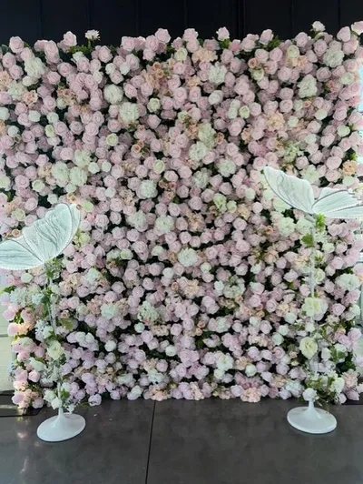 Pink flower wall backdrop with decorative butterfly lamps at graduation celebration at The Delaware Wedding & Event Space