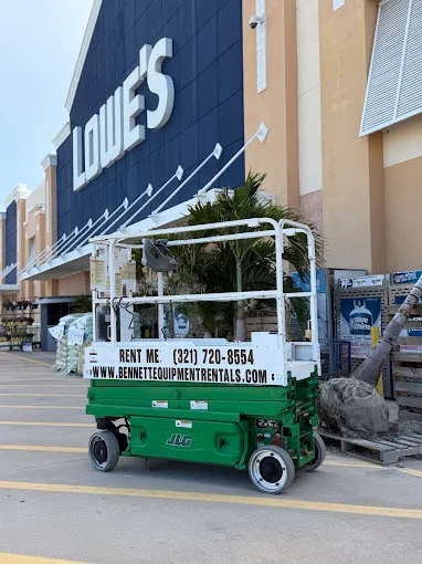 Contractor using a Bennett Equipment Rentals electric scissor lift for commercial maintenance in Melbourne, Florida.
