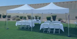White pop-up canopy providing shade over tables and chairs during an outdoor party.