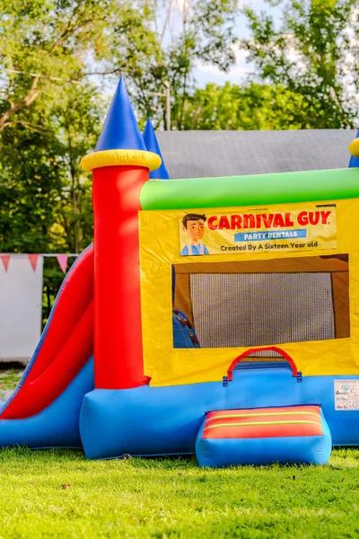 Colorful bounce house set up at an outdoor birthday party in Northeast Kansas with children enjoying the inflatable.
