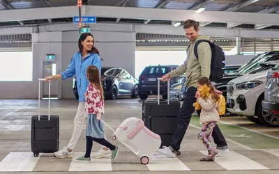 Family arriving into Auckland International Airport NZ with assistance using stroller