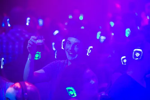 Man op een silent disco feestje met headset op
