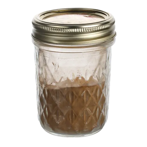 Small Clear Mason Jar With Tin Lid Containing Cinnamon