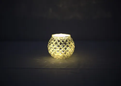 White candle jar with silver metallic pattern and lights