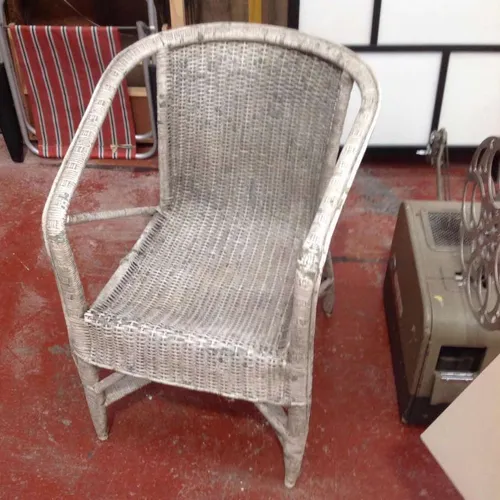 Aged white wicker armchair