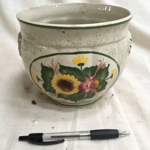 Ceramic planter with painted flower details and green trim