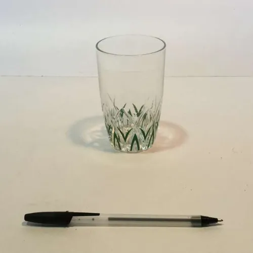 small glass tumbler with green cris cros detail at bottom