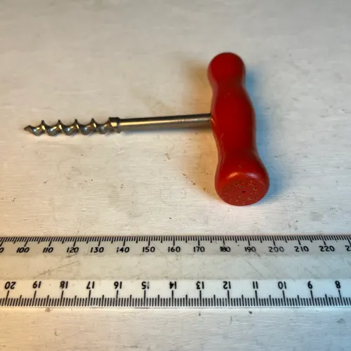 Old corkscrew with red handle