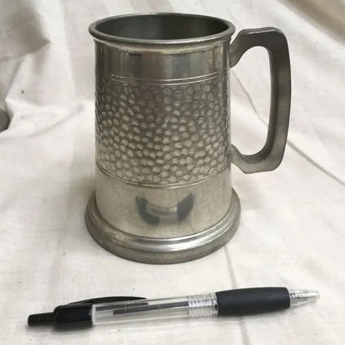 Metal tankard with indentations and line detailing 
