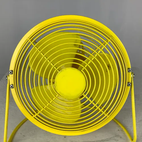 Small yellow desk fan with stand
