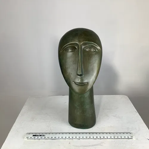 Light, bronze-like face figurine