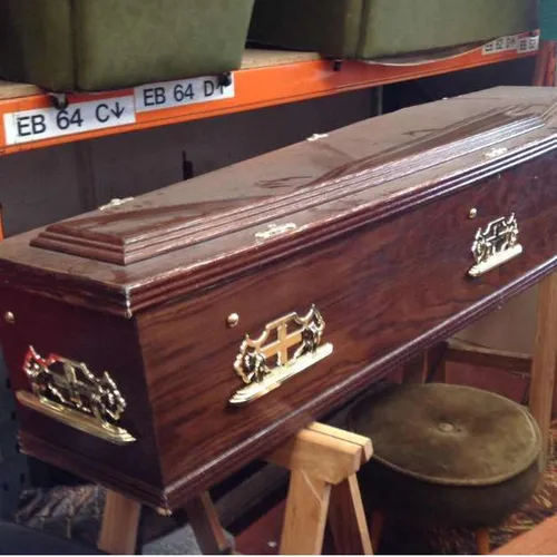 Full sized wooden coffin with ornate gold handles