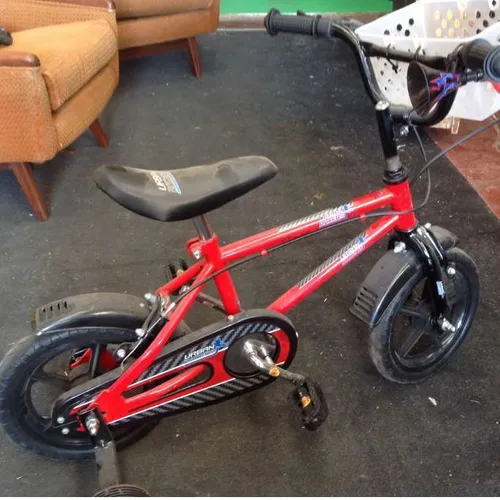 red and black childrens' bicycle with training wheels / stabilisers basket and horn