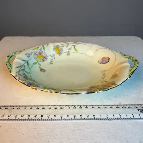 Porcelain serving dish with painted flowers and green handles