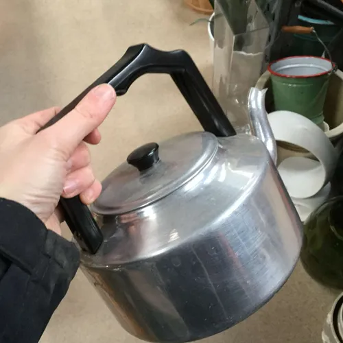 Metal teapot with black handle