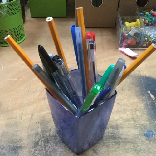 Blue plastic pen pot with stationary 
