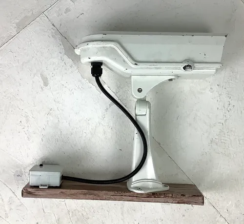 Cream Security CCTV Camera on a Dummy Dark Wooden  Plank