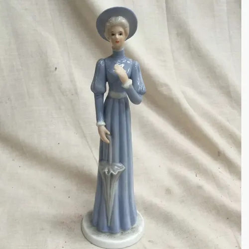 Figurine of a woman in blue dress with umbrella