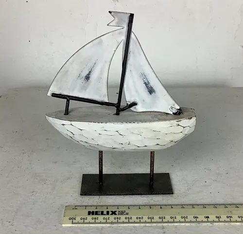 White Model Sailboat on Black Metal Stand