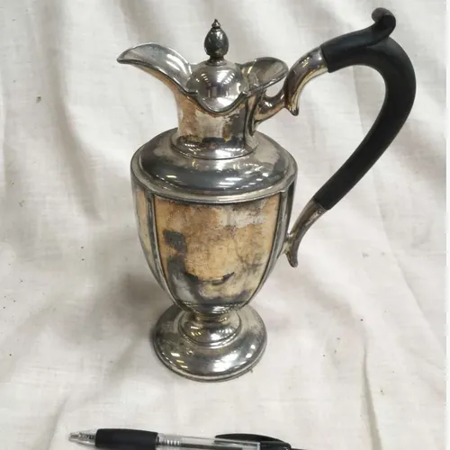 Period silver coffee pot with black handle