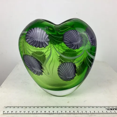 Green glass heart shaped vase with heavy base and pale blue leaves decoration