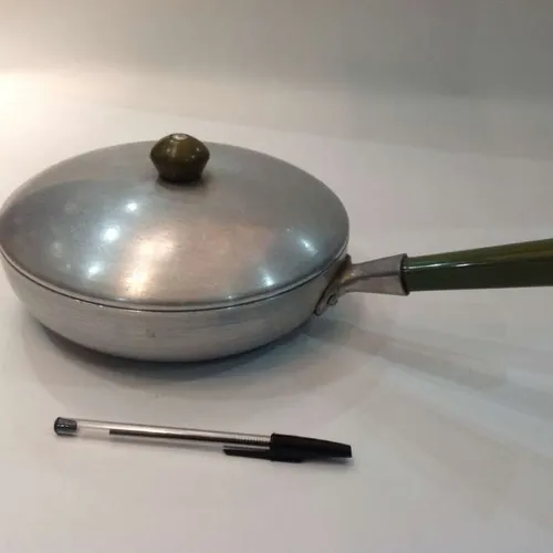 frying pan with green handle and lid