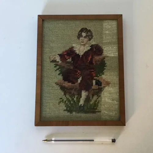 tapestry style picture of figure in red clothing, cream background with wooden frame