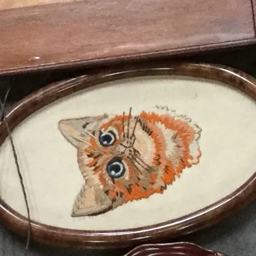 Oval frame with cross stitch animal designs