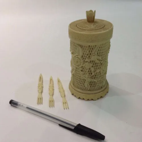 set of cream plastic cocktail forks in ornate container