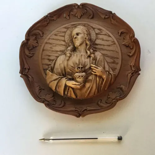 circular wooden carved panel of Jesus Christ head and body with decorative edge