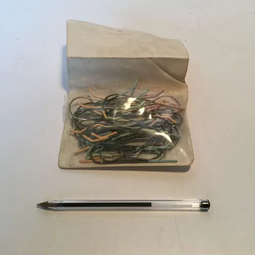 Off white pouch containing metal 's' hooks with assorted coloured end