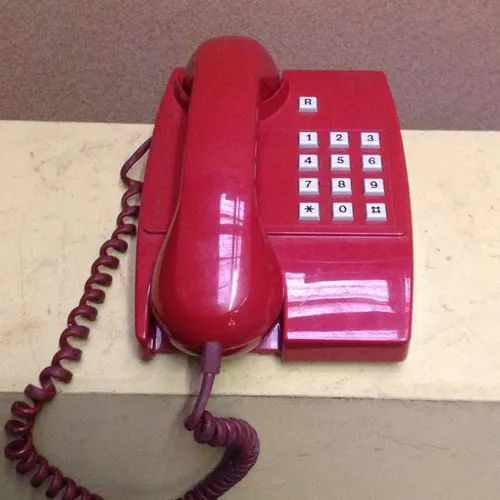 red Philips corded telephone with white push buttons