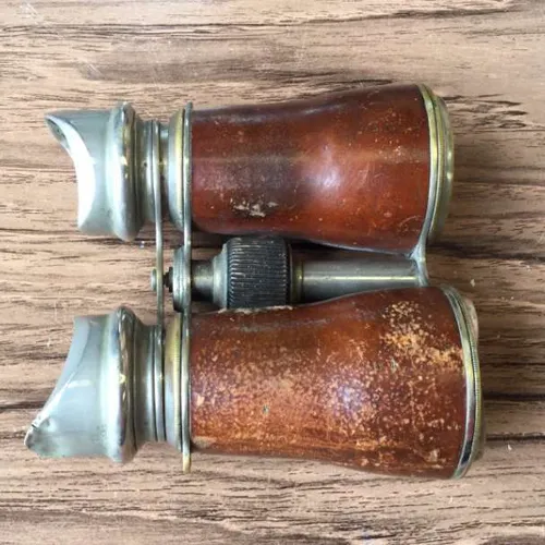 binoculars with well-worn brown leather covering and silver / metal eye pieces