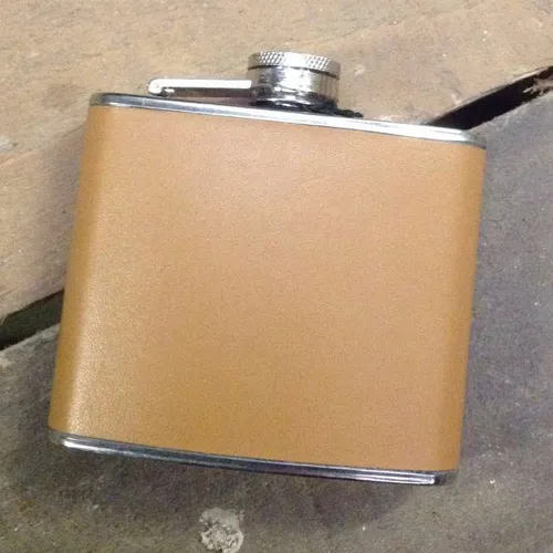 half size silver flask with tan leather cover