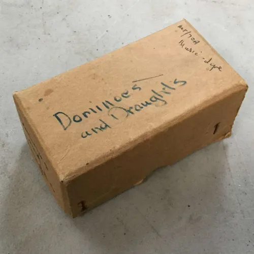 Cardboard box of dominoes and draughts